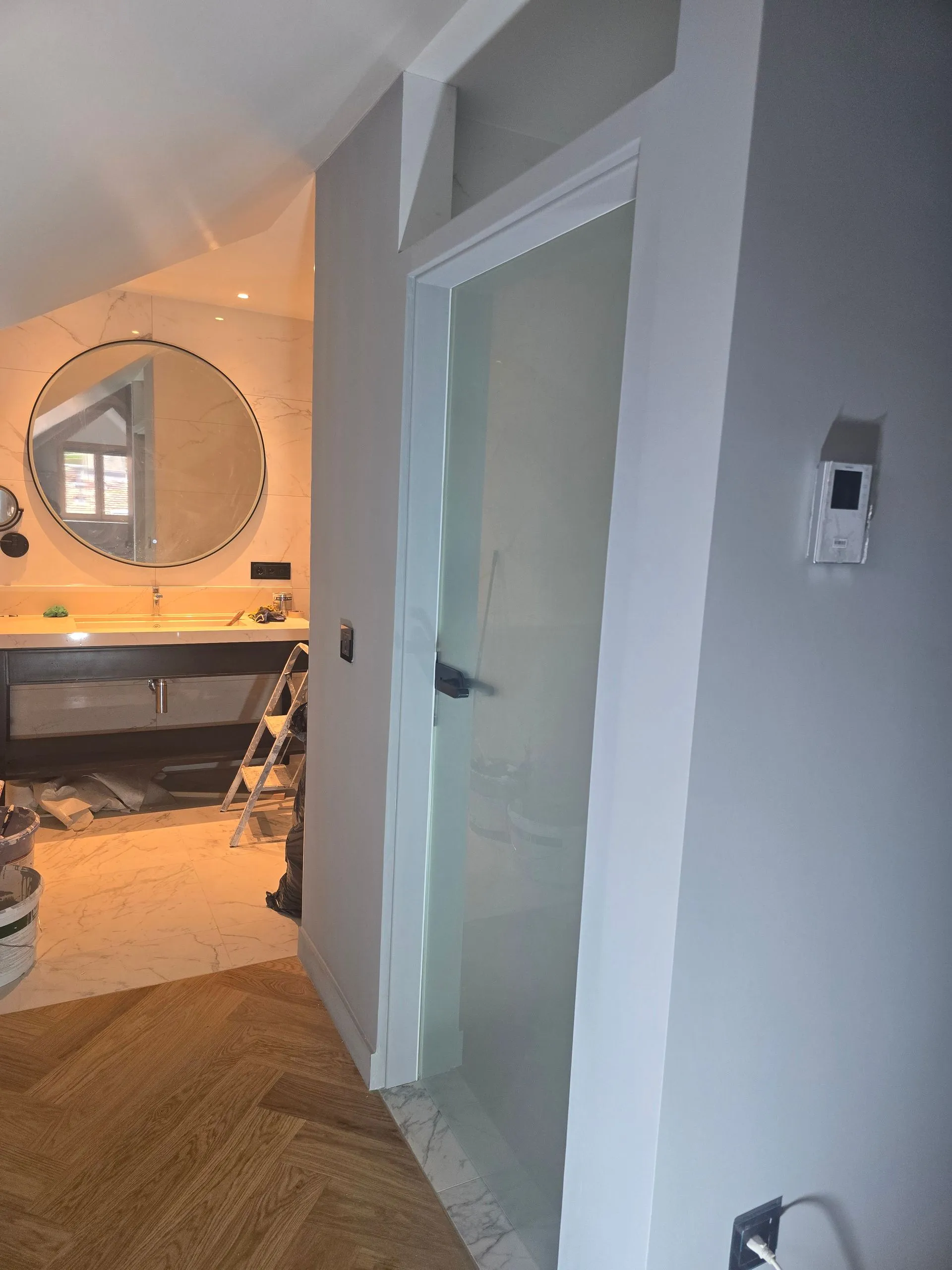 Parquet en chevrons et entrée de salle de bain dans une chambre de l’hôtel