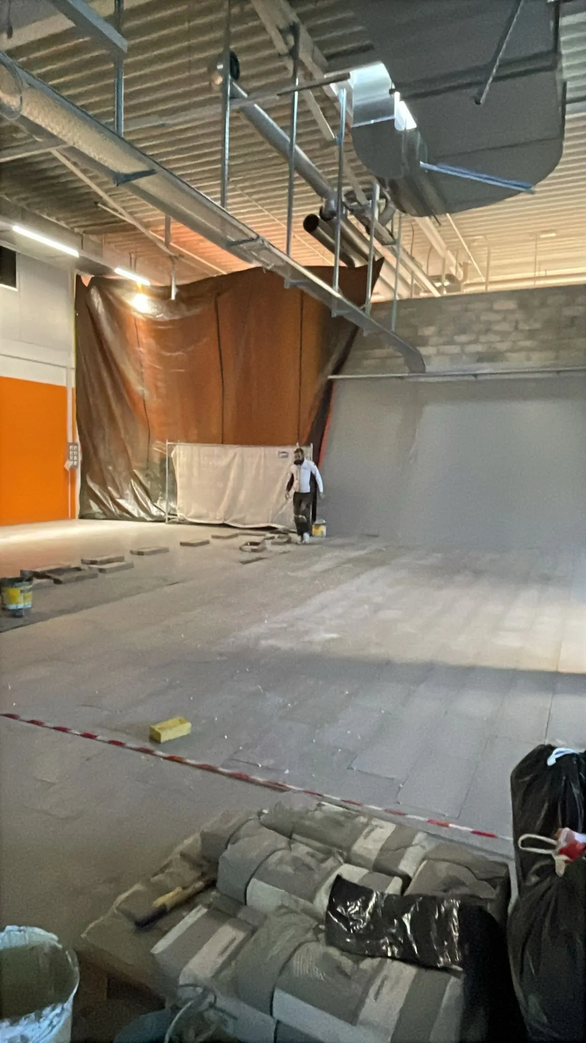 Zone de vente en travaux, sol carrelé et mur orange