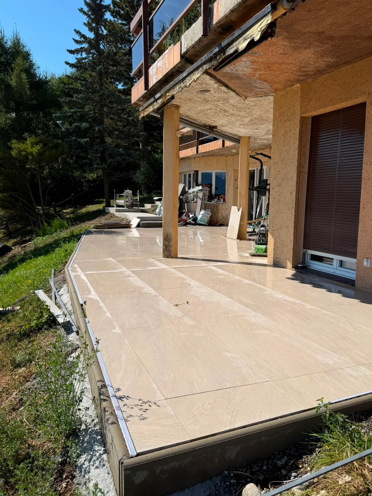 Bord de la terrasse : dalles de grès cérame tenues par un profilé de retenue