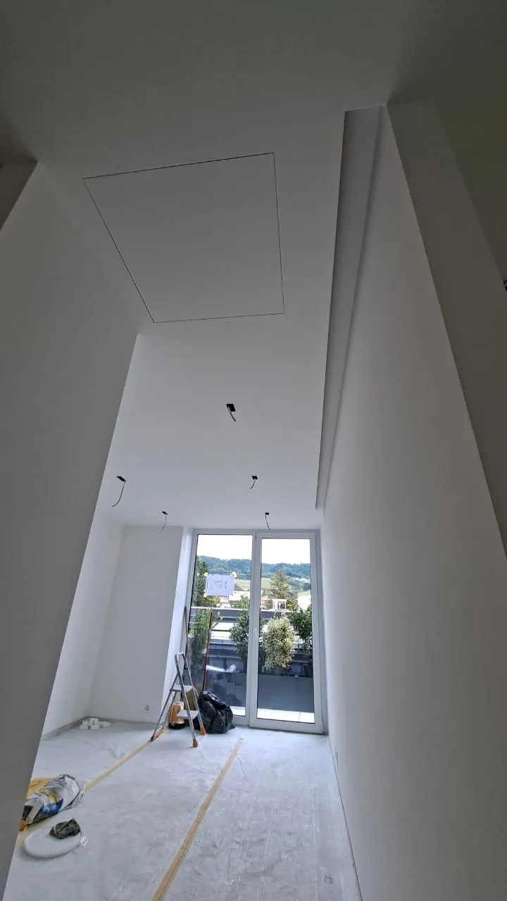 Chambre d’un appartement de La Baie d’Opale à Rolle, faux-plafond et grande fenêtre
