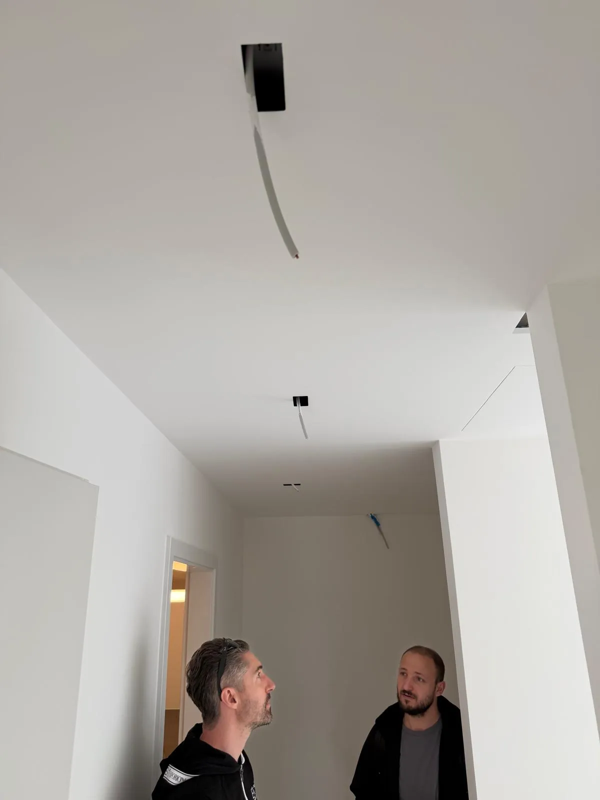 Deux membres de l’équipe BNG contrôlent les plafonds de l’appartement