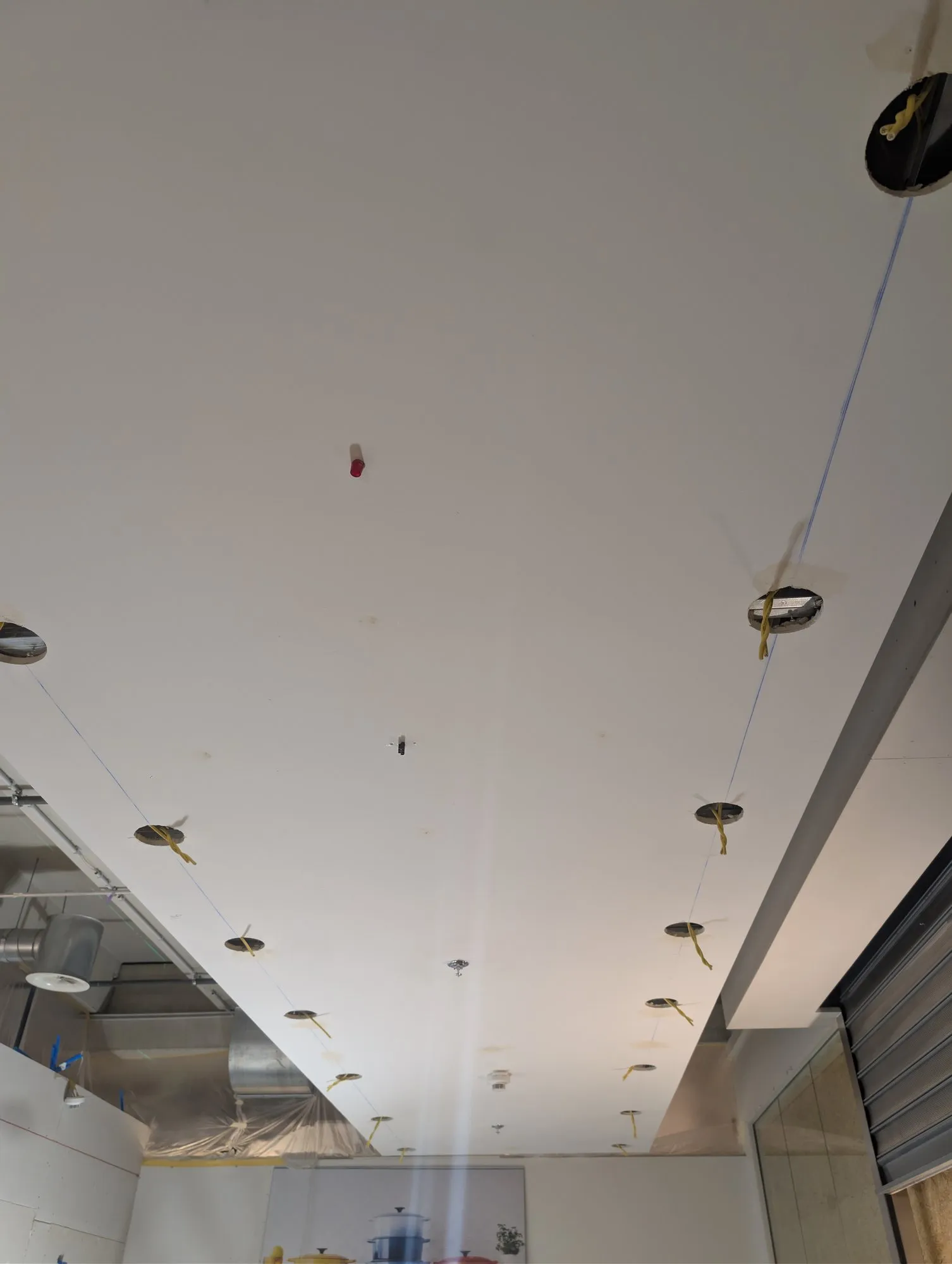 Faux-plafond percé pour les spots encastrés, avant bandes et peinture