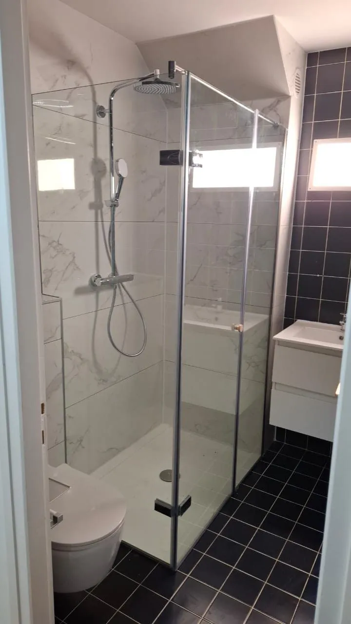 Douche à l’italienne avec paroi vitrée et carrelage noir au sol