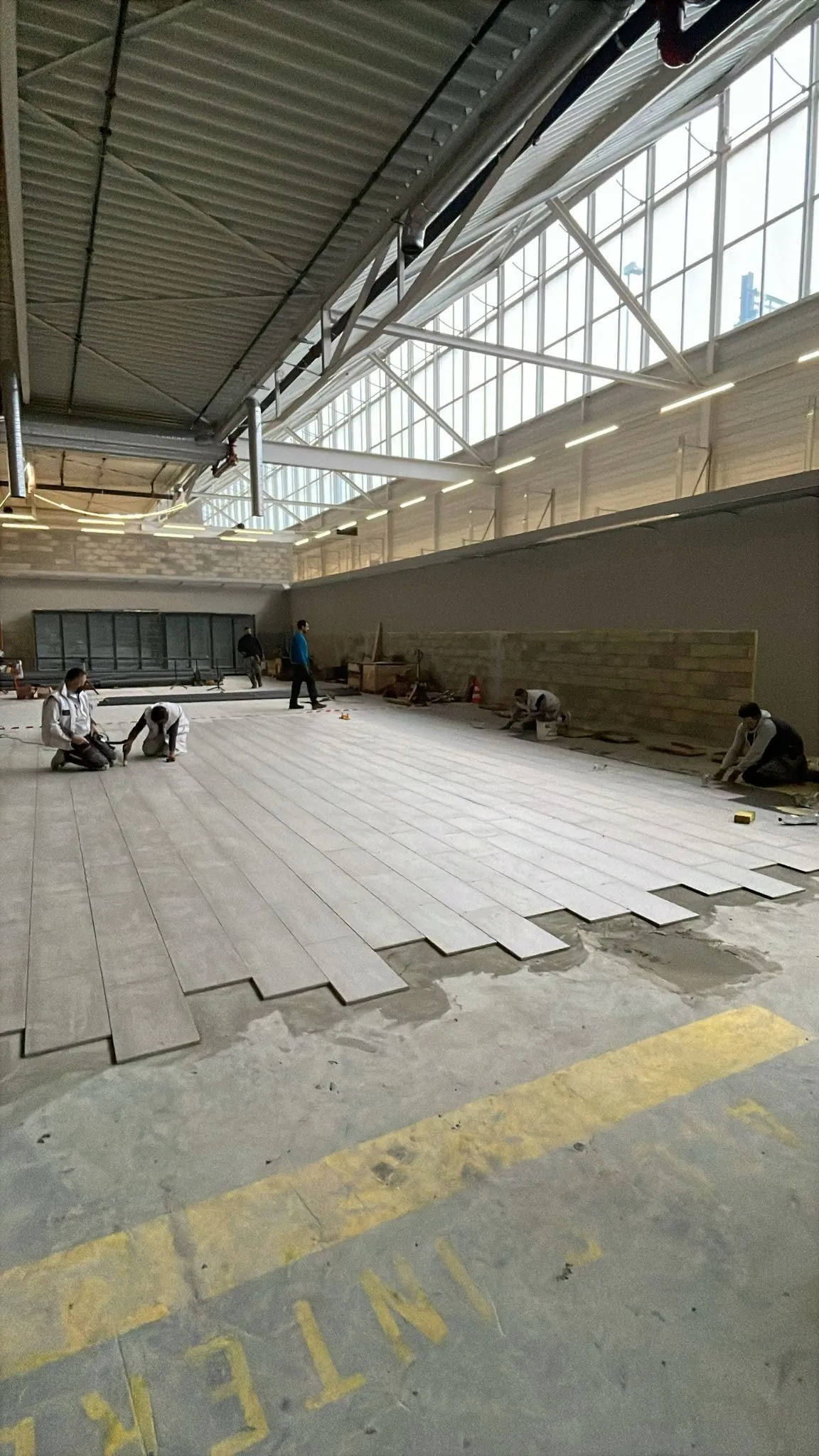Pose de carrelage grand format dans le magasin Migros / OBI de Renens