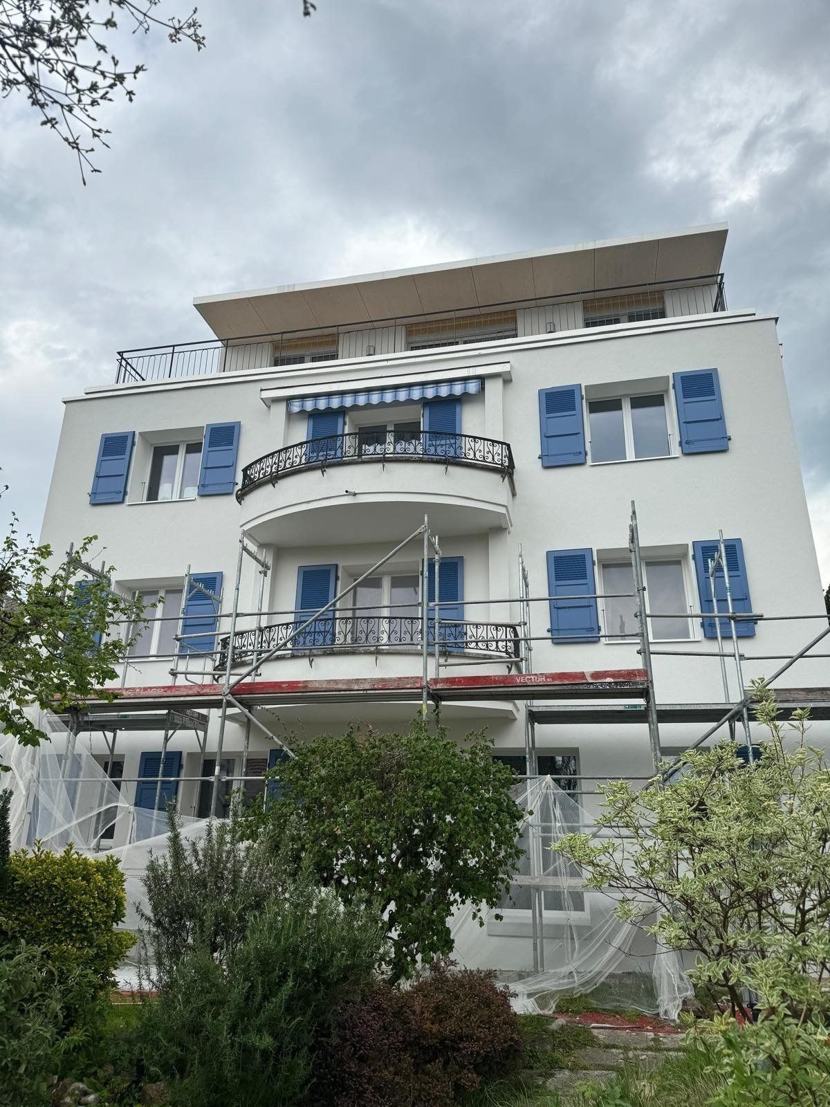 Façade blanche aux volets bleus de la villa de Corseaux, après les travaux