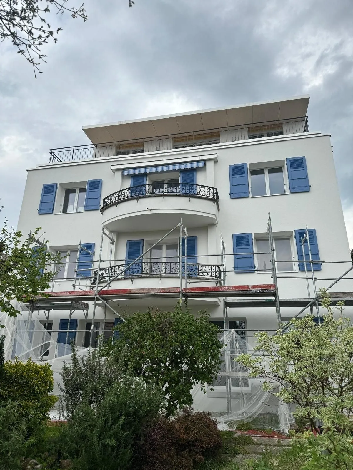 Façade blanche aux volets bleus de la villa de Corseaux, après les travaux